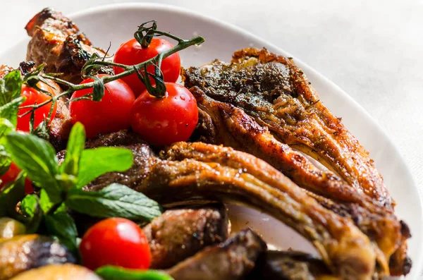 Taze, ev yapımı et şişleri, sebze ve baharatlı, barbekü soslu ve ketçaplı, yakın plan beyaz bir tabakta.