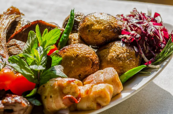 Taze, ev yapımı et şişleri, sebze ve baharatlı, barbekü soslu ve ketçaplı, yakın plan beyaz bir tabakta.