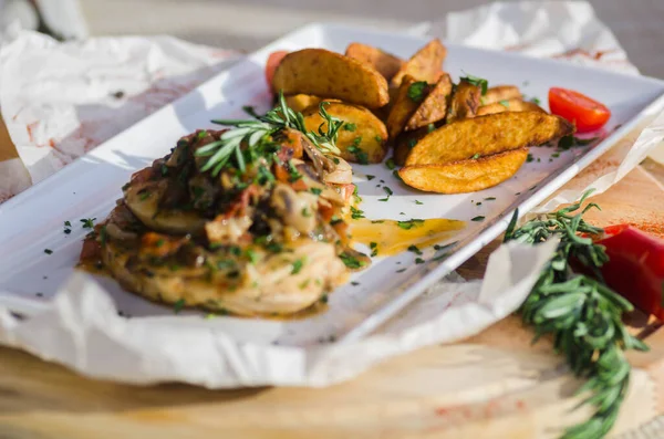 Mantar soslu tavuk göğsü ve masada patates kızartması..