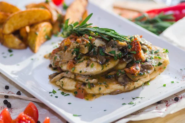 Mantar soslu tavuk göğsü ve masada patates kızartması..