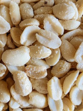 Roasted peanuts, salty snacks. Peeled peanuts for background, top view.