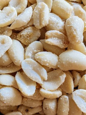 Roasted peanuts, salty snacks. Peeled peanuts for background, top view.