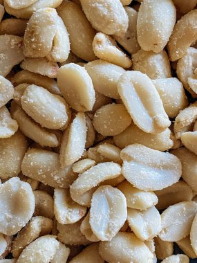 Roasted peanuts, salty snacks. Peeled peanuts for background, top view.