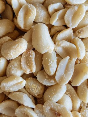 Roasted peanuts, salty snacks. Peeled peanuts for background, top view.