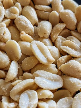 Roasted peanuts, salty snacks. Peeled peanuts for background, top view.