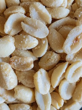 Roasted peanuts, salty snacks. Peeled peanuts for background, top view.