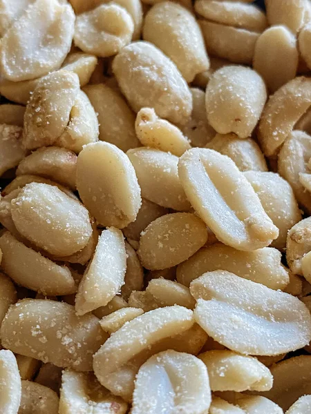 Roasted peanuts, salty snacks. Peeled peanuts for background, top view.