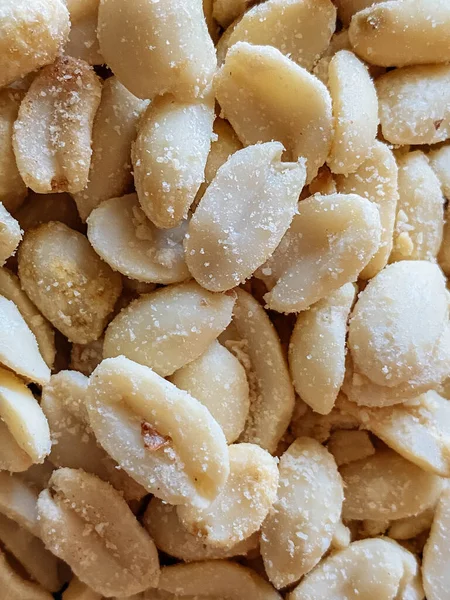 Roasted peanuts, salty snacks. Peeled peanuts for background, top view.