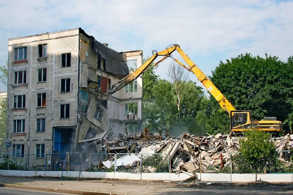 Grävmaskin demolerar den gamla sovjetiska lägenhet hus i Moskva Stockbild