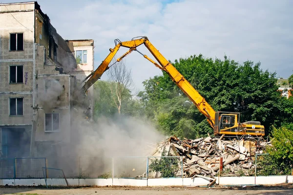 Grävmaskin demolerar den gamla sovjetiska bostadshus i Moskva Royaltyfria Stockbilder