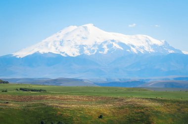 Avrupa 'nın en yüksek dağı Elbrus, 5642 metre. Rusya 'da, Kafkasya' da. Elbrus volkanik kökenlidir ve iki zirvesi vardır. Büyük karlı dağ yeşil vadinin üzerinde yükseliyor.