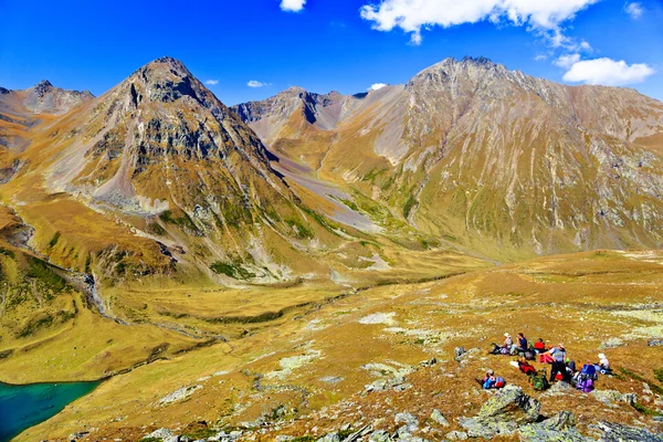 Group of hiking tourists on a halt at the pass. — Stock Photo, Image