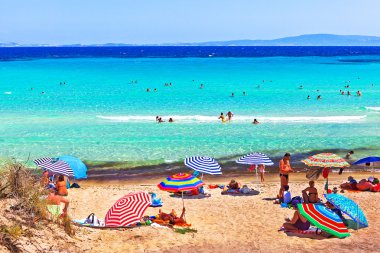 güneşlenme ve kalkan Ege Denizi'nin sahilde insanlar