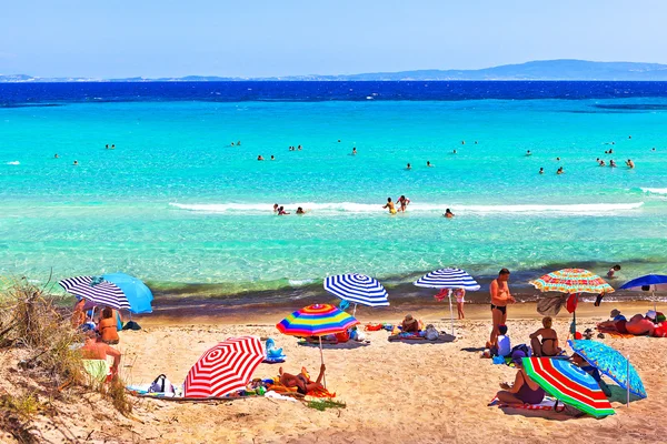 Mensen te zonnebaden en swimmig op het strand van de Egeïsche zee — Stockfoto