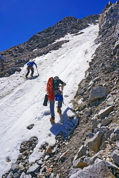 登山者组使攀登这座山在白雪覆盖的山坡上情节 — 图库照片