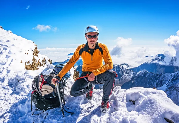 在构成上的雪山背景的山顶上的登山者 — 图库照片