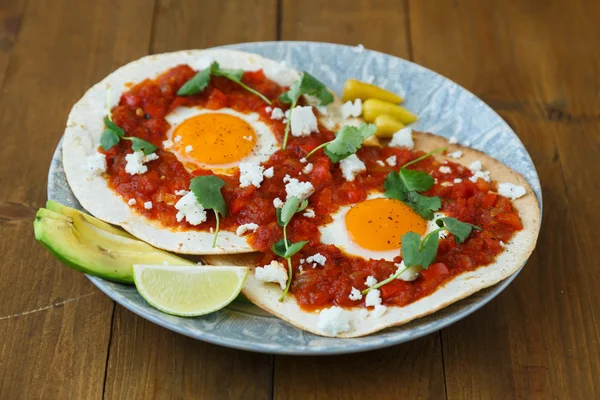 Desayuno con huevo frito y salsa en tortilla a la parrilla, huevos mexicanos rancheros —  Fotos de Stock