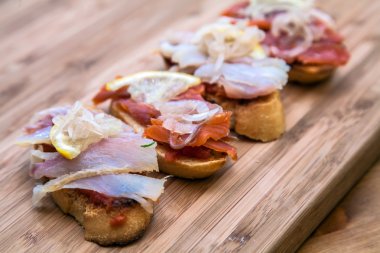 Tepesinde kırmızı ve beyaz balık, limon, maydanoz ile tapas