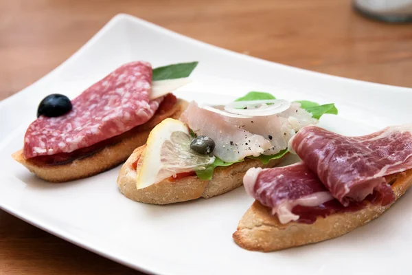 Tasty homemade tapas with different fillings on the table — Stock Photo, Image