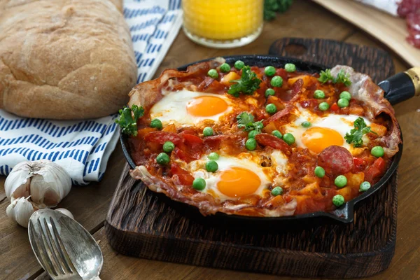 Huevos escalfados en salsa de tomate y otras verduras servidas con pan . — Foto de Stock