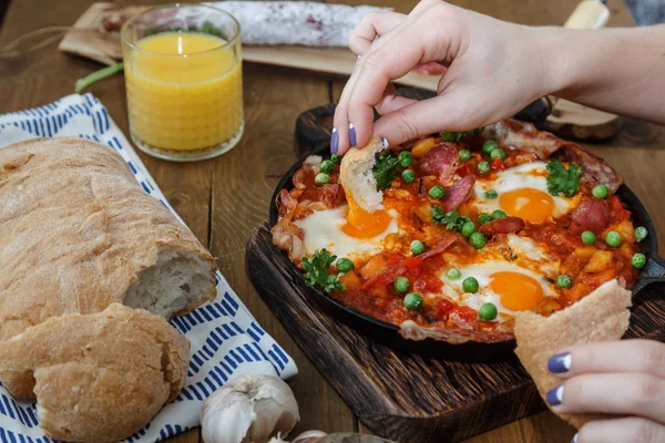 Kézi dip kenyér flamenco tojásokat vagy huevos la flamenca, andalúz ételeket — Stock Fotó