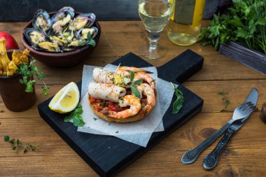 İtalyan yemeği. Bruschetta kalamar ve karides, domates, maydanoz.