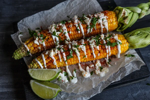 Elote oder mexikanische gegrillte Maiskolben, serviert mit Cotija-Käse und Chilipulver. — Stockfoto