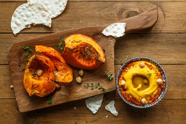 Kabak humus ve kavrulmuş Balkabagi ahşap arka plan üzerinde. Üstten Görünüm, rustik tarzı