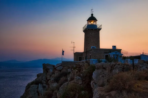 Maják na pobřeží při západu slunce, řecké pobřeží — Stock fotografie