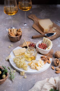 İncir, fındık, üzüm ve bal ile mermer tabakta çeşitli peynirler.