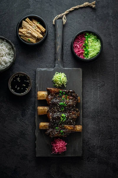 Estofado de carne de res costillas cortas, estilo asiático con arroz y rábano, foto oscura, acostado plano — Foto de Stock