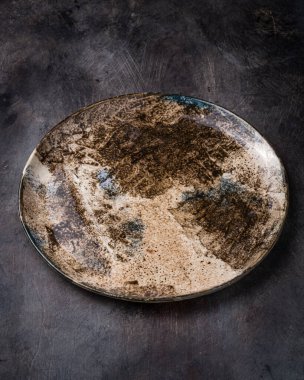 El yapımı seramik plaka. Koyu taştan arka plan. Uzayı kopyala.