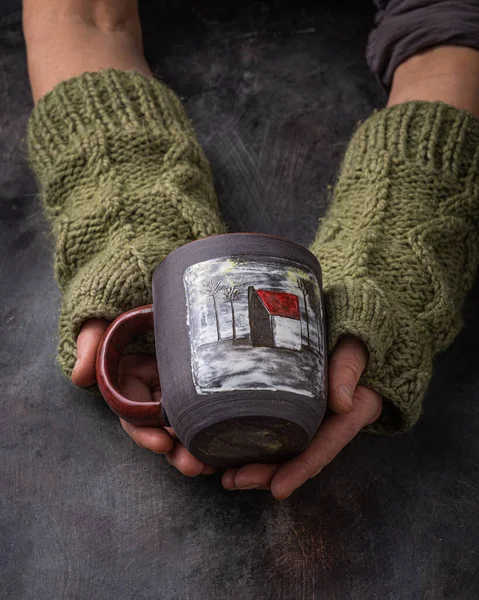 Hand made cup in female hands, dark photo