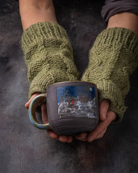 Hand made cup in female hands, dark photo