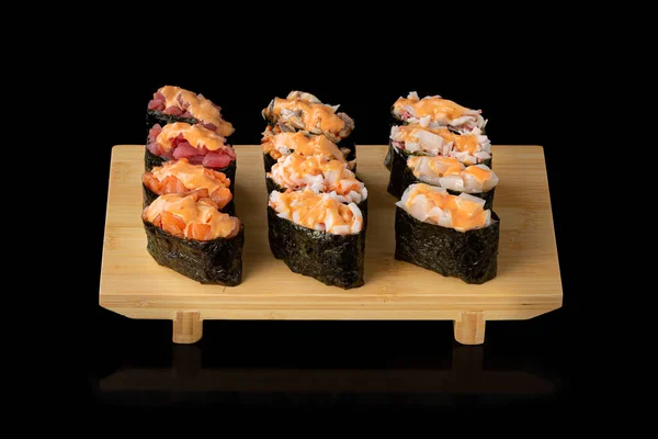 Set de sushi. Rollos con caviar rojo anguila salmón y verduras sobre fondo negro — Foto de Stock