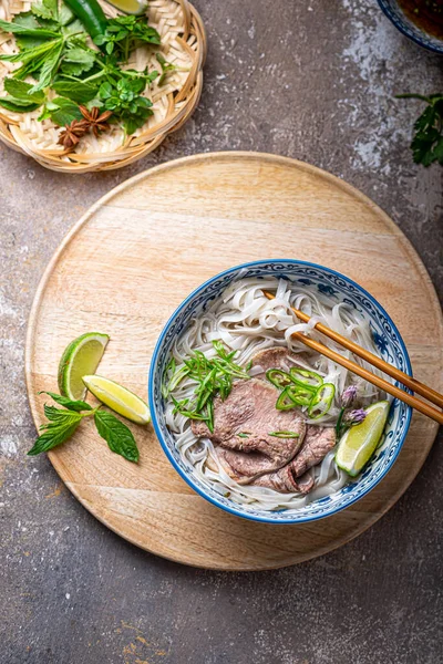 Top view of pho bo vietnamese rice noodle soup with herbs and sauce — Stock Photo, Image