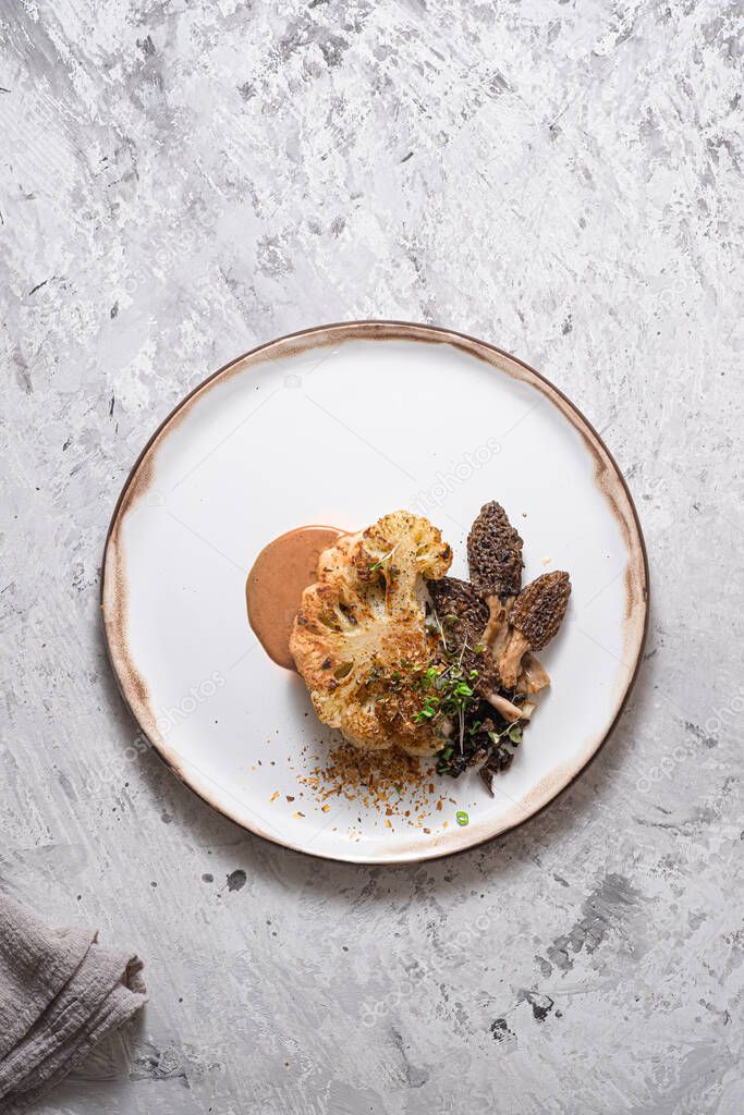Cauliflower steak with morels on plate, restaurant dish, copy space