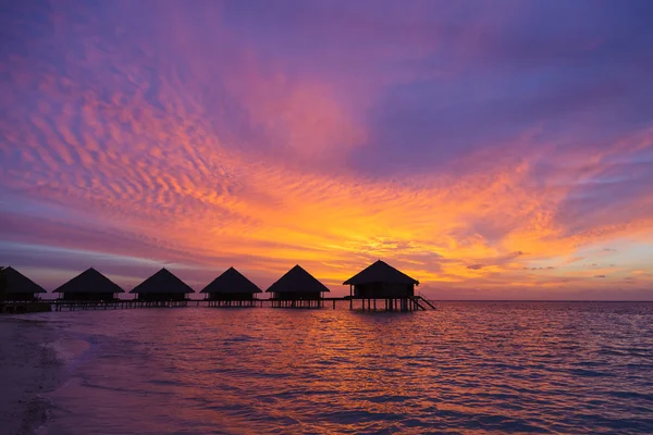 Günbatımı manzaralı bir lagün, plaj ve bungalovlar Maldivler'de — Stok fotoğraf