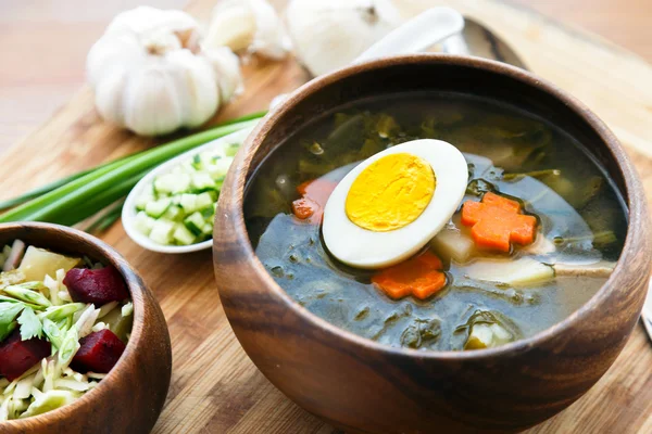 Зеленый суп с яйцами и соплями в миске — стоковое фото