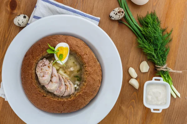 Traditional white borscht with sausage, egg in bread — Stock Image Traditional white borscht with sausage, egg in bread Stock Photo
