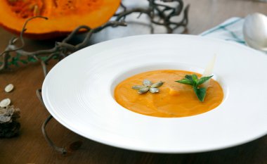 Sonbahar dekorasyonları ile tabloda ev yapımı krem balkabağı çorbası.