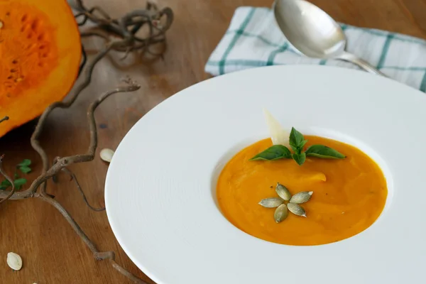 stock image squash soup in a plate with basil leaf