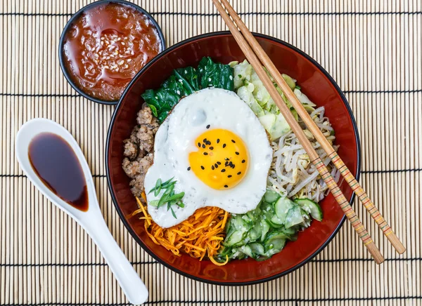 Bibimbap bir kase bambu hasır, Kore çanak üzerinde soslar