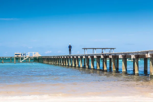 Hombre de pie en un muelle de madera — Foto de Stock