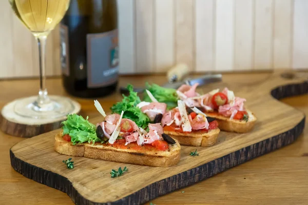 Tapas på Crusty bröd - urval av spanska tapas serveras med en skivad baguette. — Stockfoto