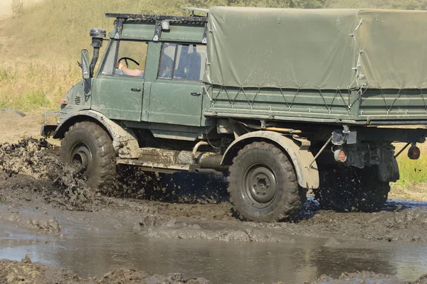 ウニモグ ドライブスルー泥の水たまり — ストック写真