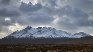 River Etive, Glencoe, İskoçya, Uk yakınlarında bir köprü. Bol suyu olan bir nehir, arkasında Stob Dearg Dağı 'nın olduğu ormanda bir resim. Büyük bir fırtınadan sonra, kışın karlı bir atmosfer