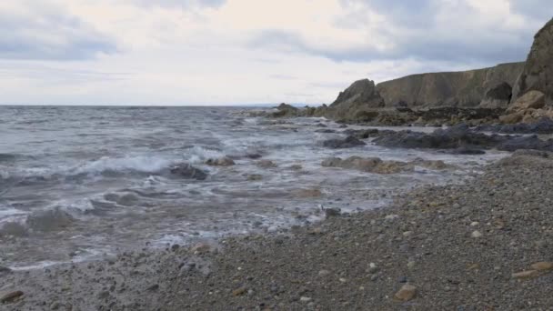 Dlouhá skalnatá pláž na mělčinovém pobřeží s oblačnou krajinou. Kilfarrasy Beach. Co.Waterford Coastline, Irsko — Stock video