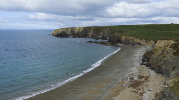 Vanuit de lucht gezien vanaf een klif van een Iers strand met bewolkt landschap. Kilfarrasy Beach. Co.Waterford Coastline, Ierland — Stockvideo