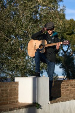 İspanyol gitarlı bir çocuk. Dizinde tutuyordu. Boşluğu kopyala